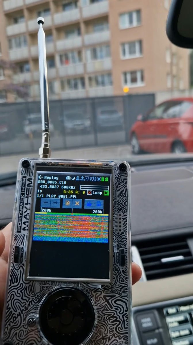 HackRF with PortaPack Mayhem in Replay mode with telescopic antenna, held in a car