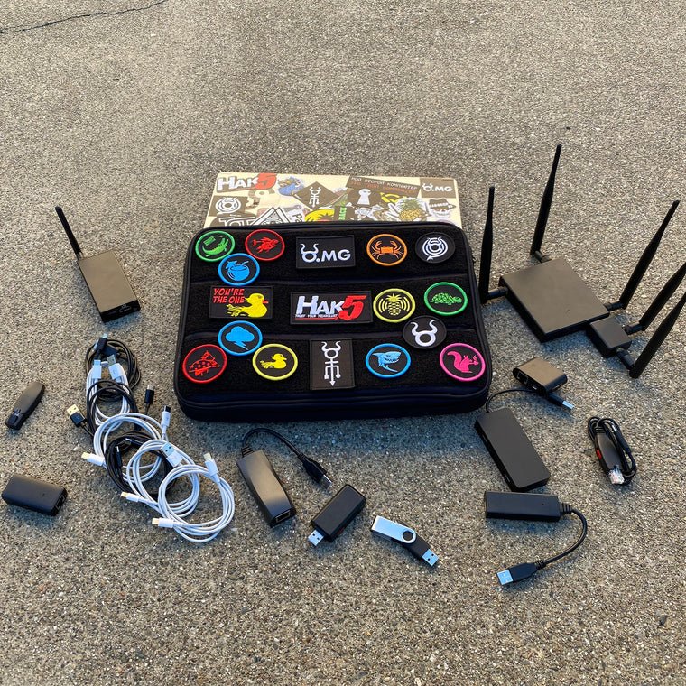 Hak5 sleeve with patches and gear spread around - routers with antennas, cables and USB adapters