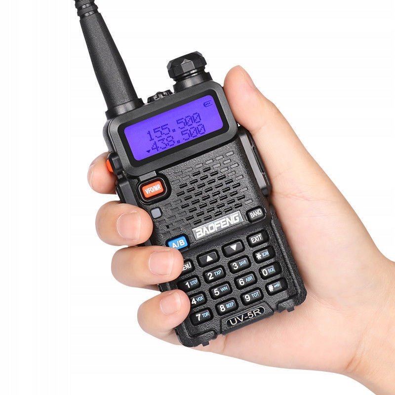 Radiotelefon Baofeng UV-5R trzymany w dłoni, z niebiesko podświetlonym wyświetlaczem i klawiaturą numeryczną