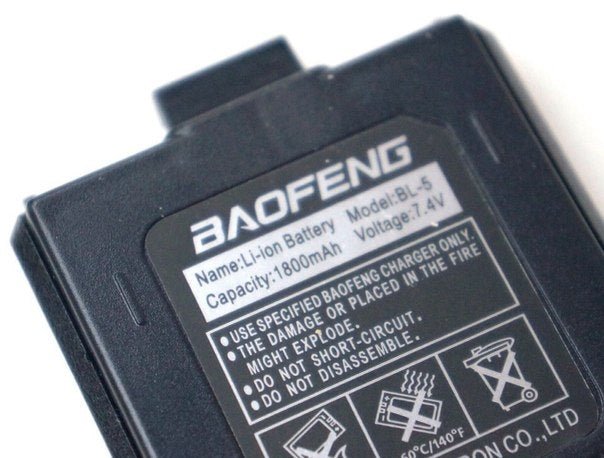 Zbliżenie etykiety akumulatora Baofeng BL-5 1800 mAh - widoczne logo BAOFENG, oznaczenie Li-ion Battery Model BL-5, pojemność 1800 mAh, napięcie 7,4 V, teksty ostrzegawcze i ikony bezpieczeństwa, na białym tle