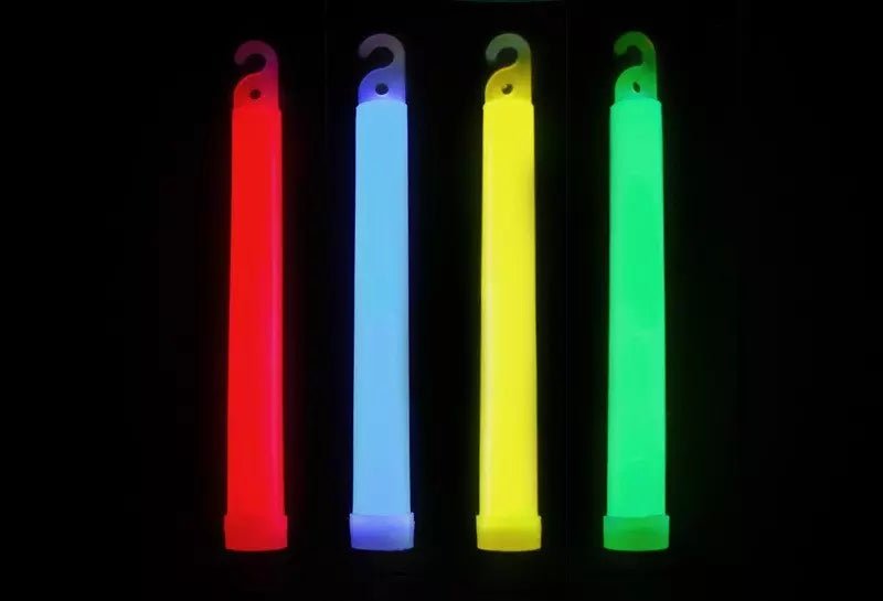 Cztery świecące światła chemiczne GlowStick - czerwone, niebieskie, żółte i zielone - ustawione pionowo na czarnym tle