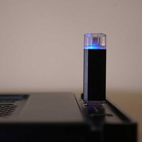 Czarny BadUSB MalDuino W podłączony do laptopa ze świecącą niebieską diodą LED na przezroczystej nakładce