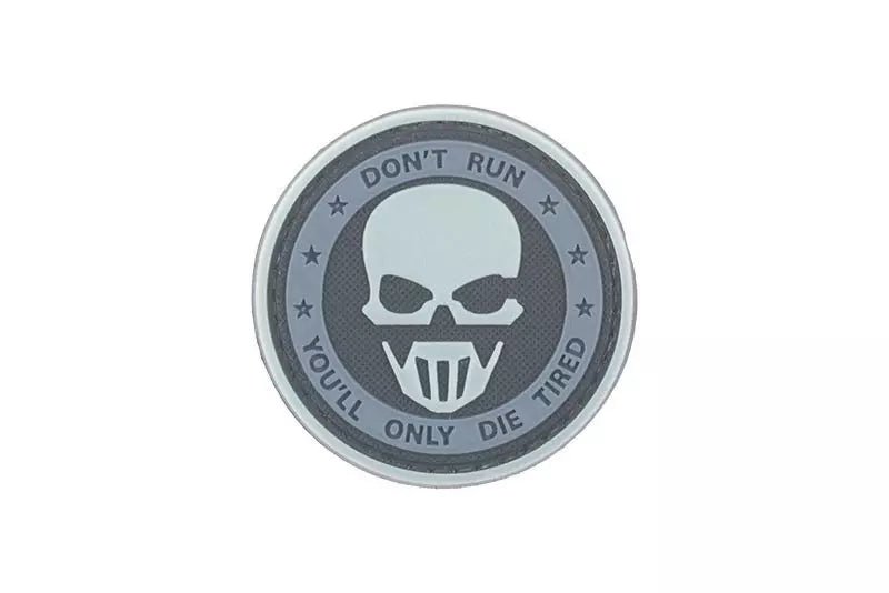 3D-Patch - ein runder grau-schwarzer Patch mit einem Schädel in der Mitte und dem Text Don't Run oben und You'll Only Die Tired unten, auf weißem Hintergrund