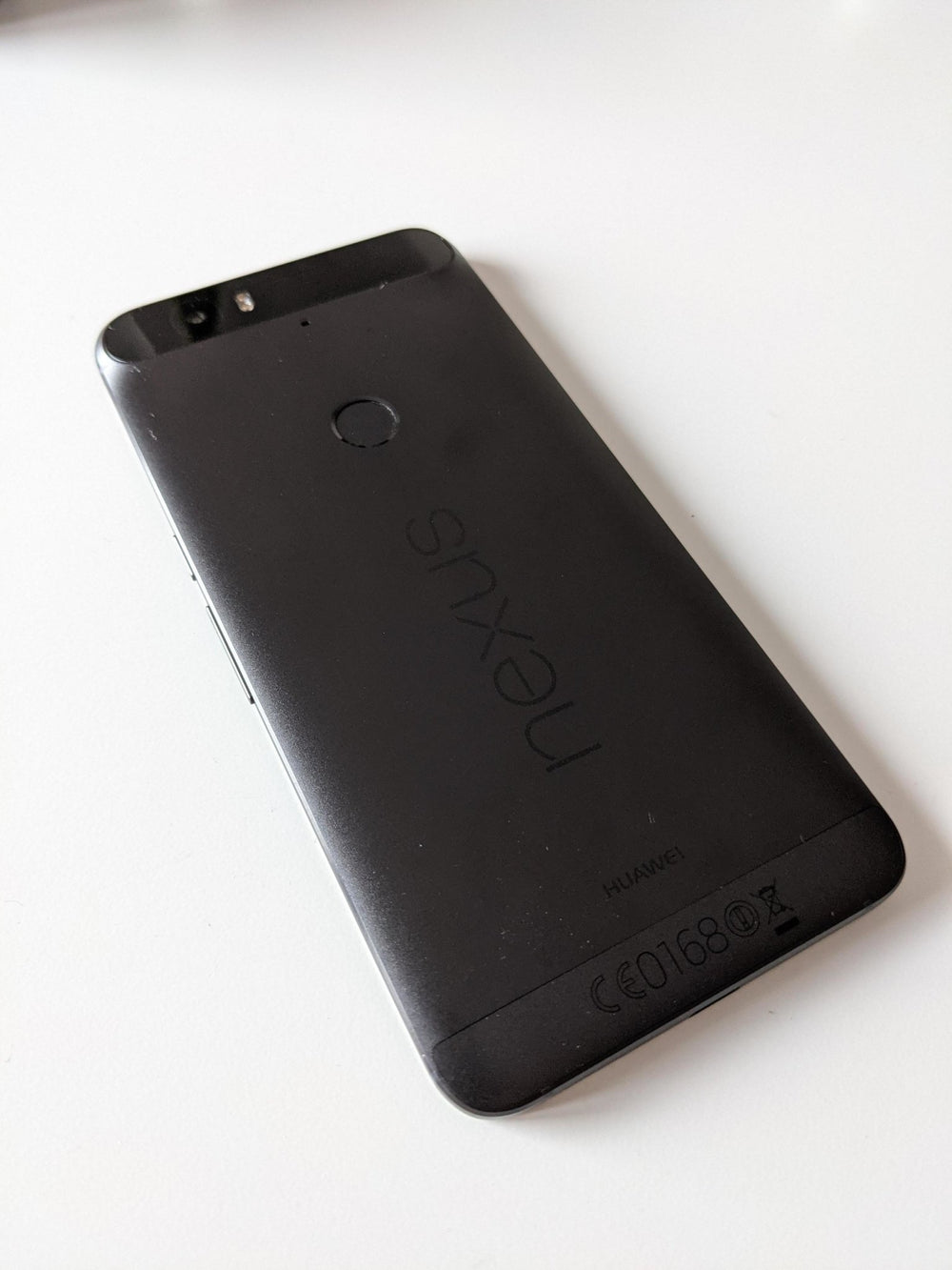 Tył czarnego smartfona Nexus 6p (Huawei) pod kątem, z paskiem aparatu, czytnikiem linii papilarnych i logo nexus