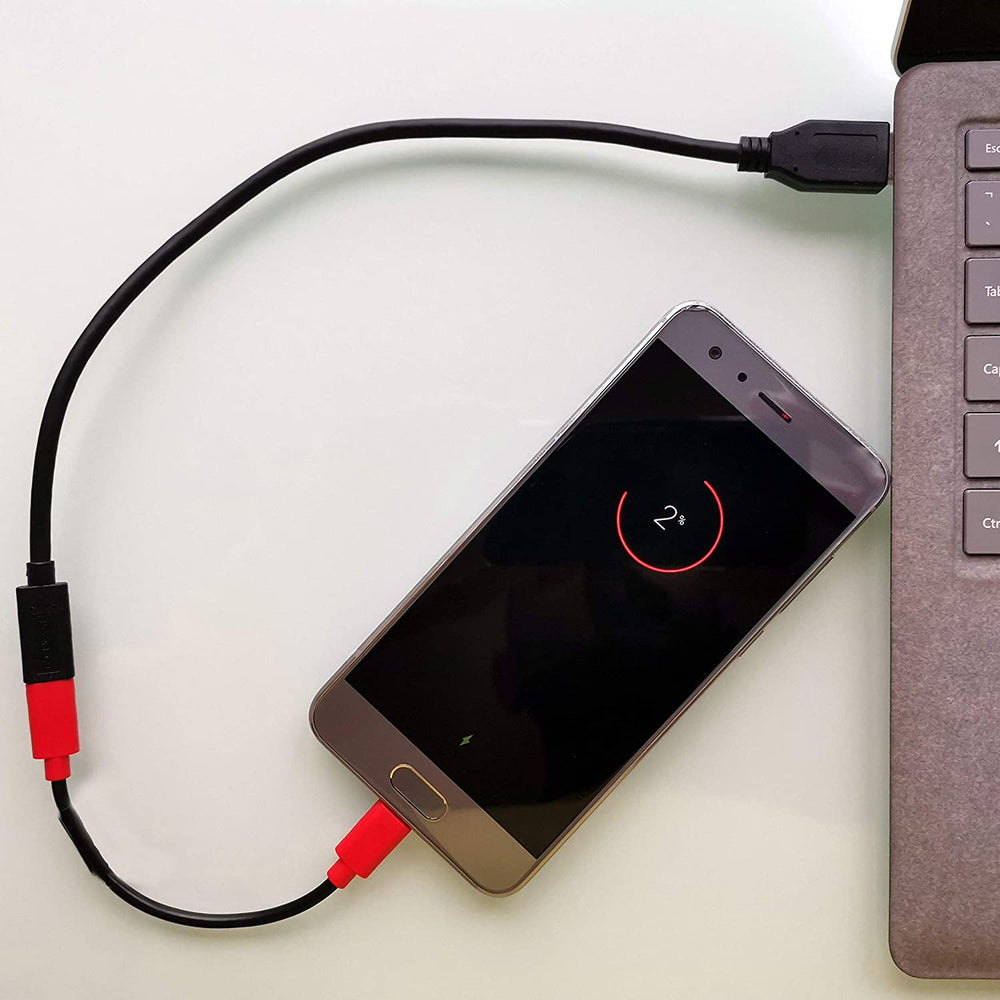 Scena użycia - kabel PortaPow Data Blocker USB-C łączący ładujący się smartfon z portem USB laptopa, umożliwia bezpieczne ładowanie bez transferu danych