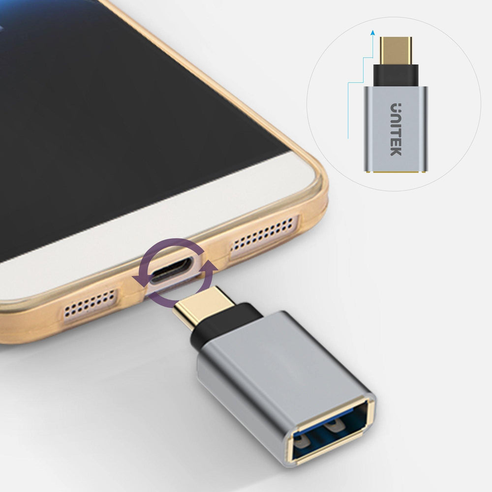 Gray Unitek Y-A025CGY OTG adapter USB-C being plugged into a smartphone, reversible USB-C plug and USB-A socket