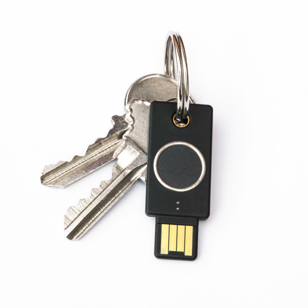 Schwarzer YubiKey Bio Schlüssel mit biometrischem Fingerabdruckleser und USB-A-Stecker an einem Bund Hausschlüssel