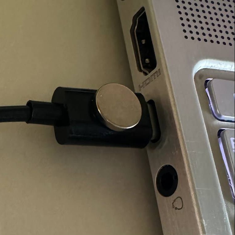 Evil Crow Cable Wind BadUSB WiFi Stecker mit Metallscheibe, eingesteckt in den seitlichen Anschluss eines Laptops neben der HDMI-Buchse