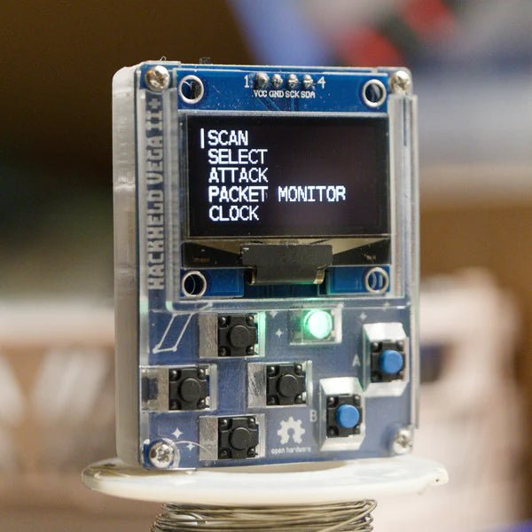 HackHeld Vega II+ - синяя плата в прозрачном корпусе с меню на OLED-дисплее, на штативе