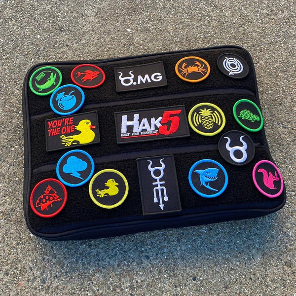Kolekcja naszywek Hak5 na czarnym pokrowcu - kolorowe okrągłe i prostokątne morale patches z motywami hakerskimi