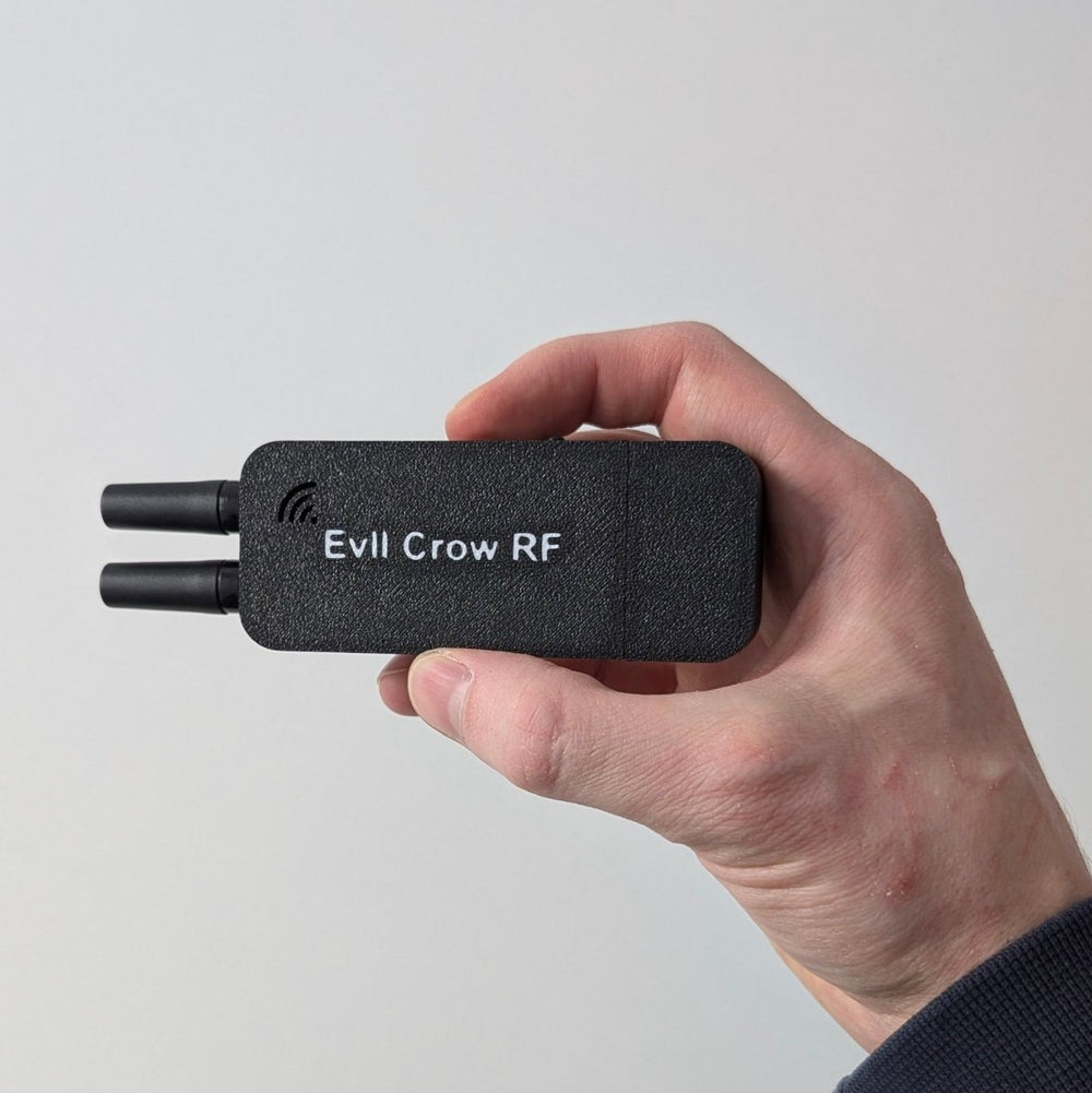 Pouzdro Evil Crow RF držené v ruce se dvěma vyčnívajícími anténami