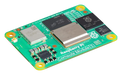 Raspberry Pi Compute Module 5 - zielona plytka pod skosem z procesorem Broadcom, pamiecia i logo maliny
