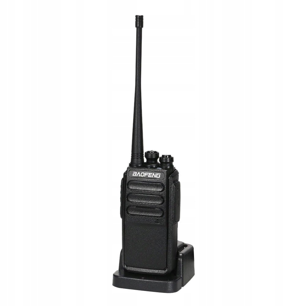 Black Baofeng C3 walkie-talkie standing in a desktop charger, with the antenna up