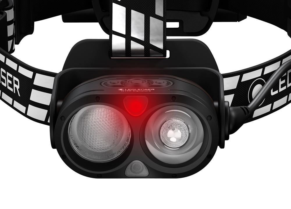 Widok od przodu na głowicę czarnej latarki czołowej Led Lenser H19R Signature z dwiema soczewkami i świecącą czerwoną diodą
