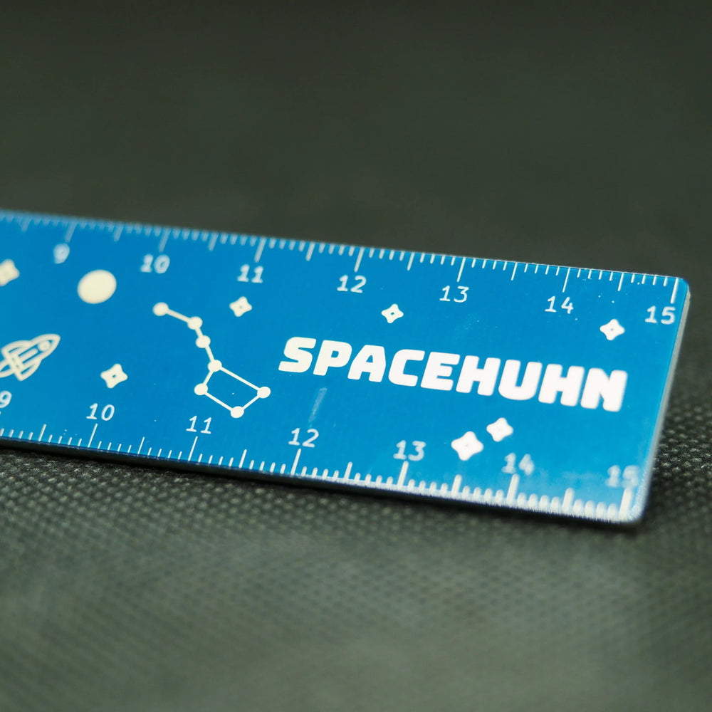 Detail modrého PCB pravítka Spacehuhn - centimetrová stupnice, souhvězdí, raketa a nápis SPACEHUHN