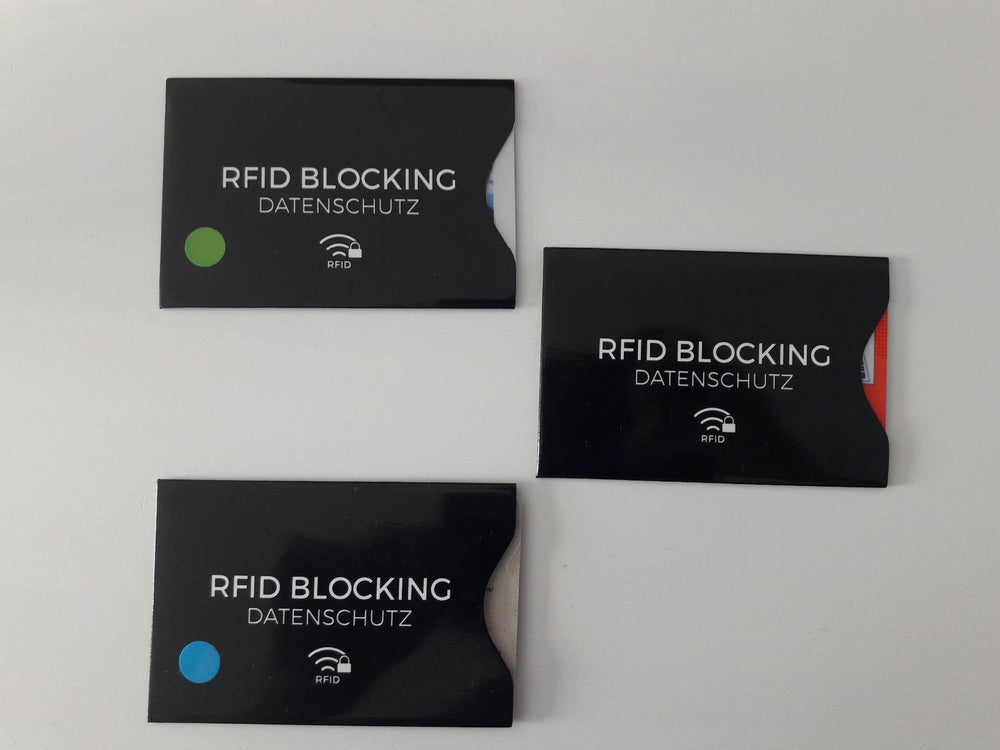 Drei schwarze RFID- und NFC-Blocker-Kartenhüllen mit eingeschobenen Karten und bunten Markierungsaufklebern - tatsächliches Produktfoto