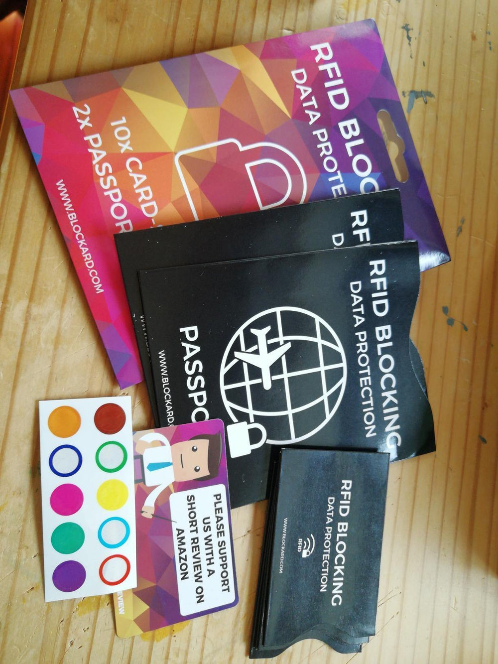 Inhalt des RFID- und NFC-Blocker-Sets auf einem Tisch ausgelegt - Verpackung, Reisepass- und Kartenhüllen und Markierungsaufkleber