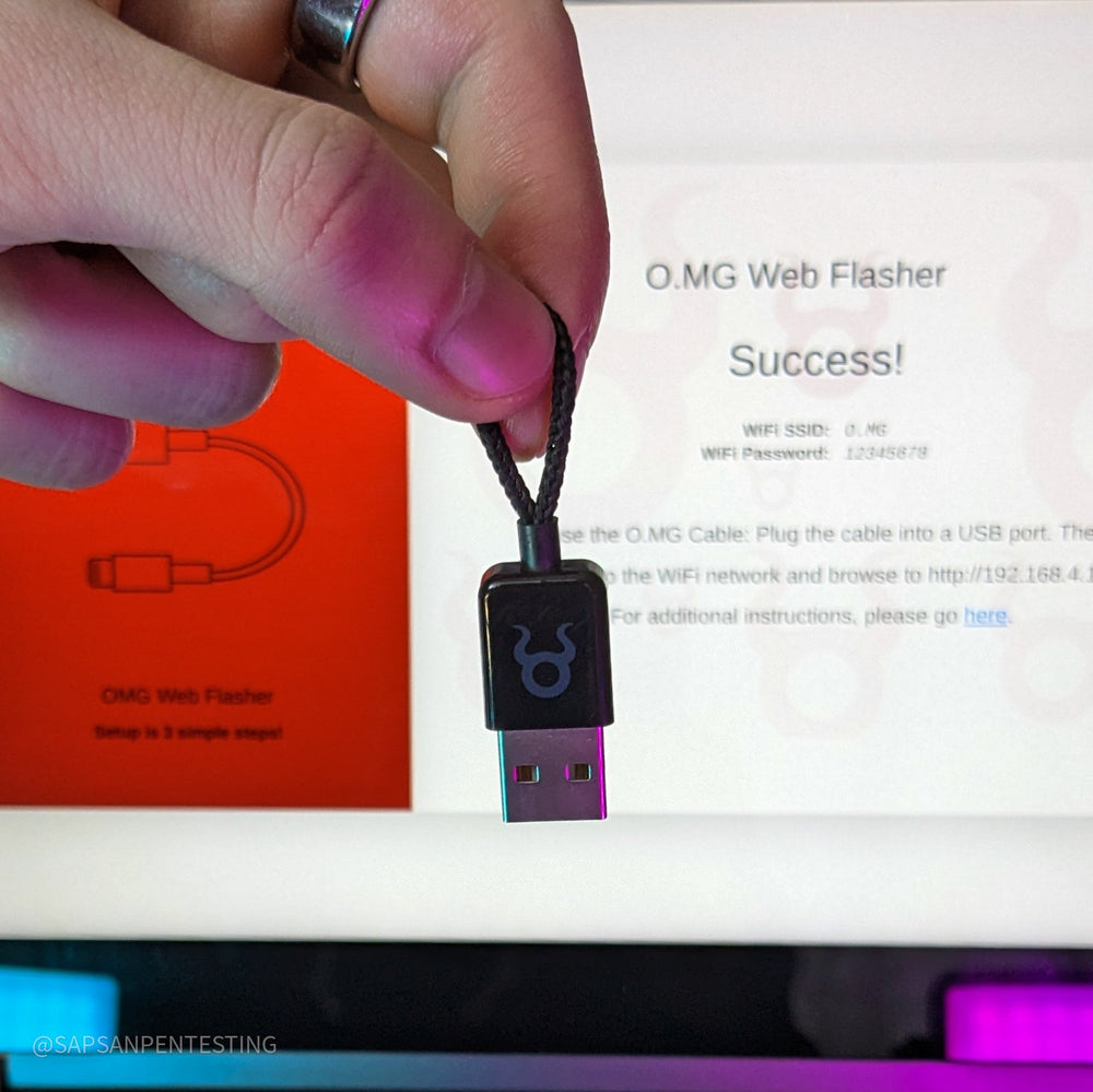 Ruka drží černý O.MG Plug na pozadí obrazovky s panelem O.MG Web Flasher a hlášením Success a pokyny k nastavení; v rohu vodoznak @SAPSANPENTESTING, fialovo-růžové světlo