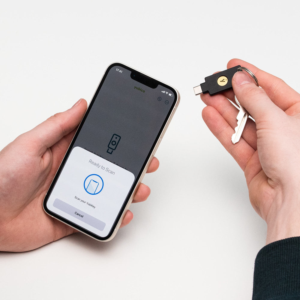 Nutzungsszene - eine Hand hält den Yubico Security Key C NFC Schlüssel an einem Schlüsselring neben einem Smartphone mit der Yubico-App, bereit zum NFC-Scannen