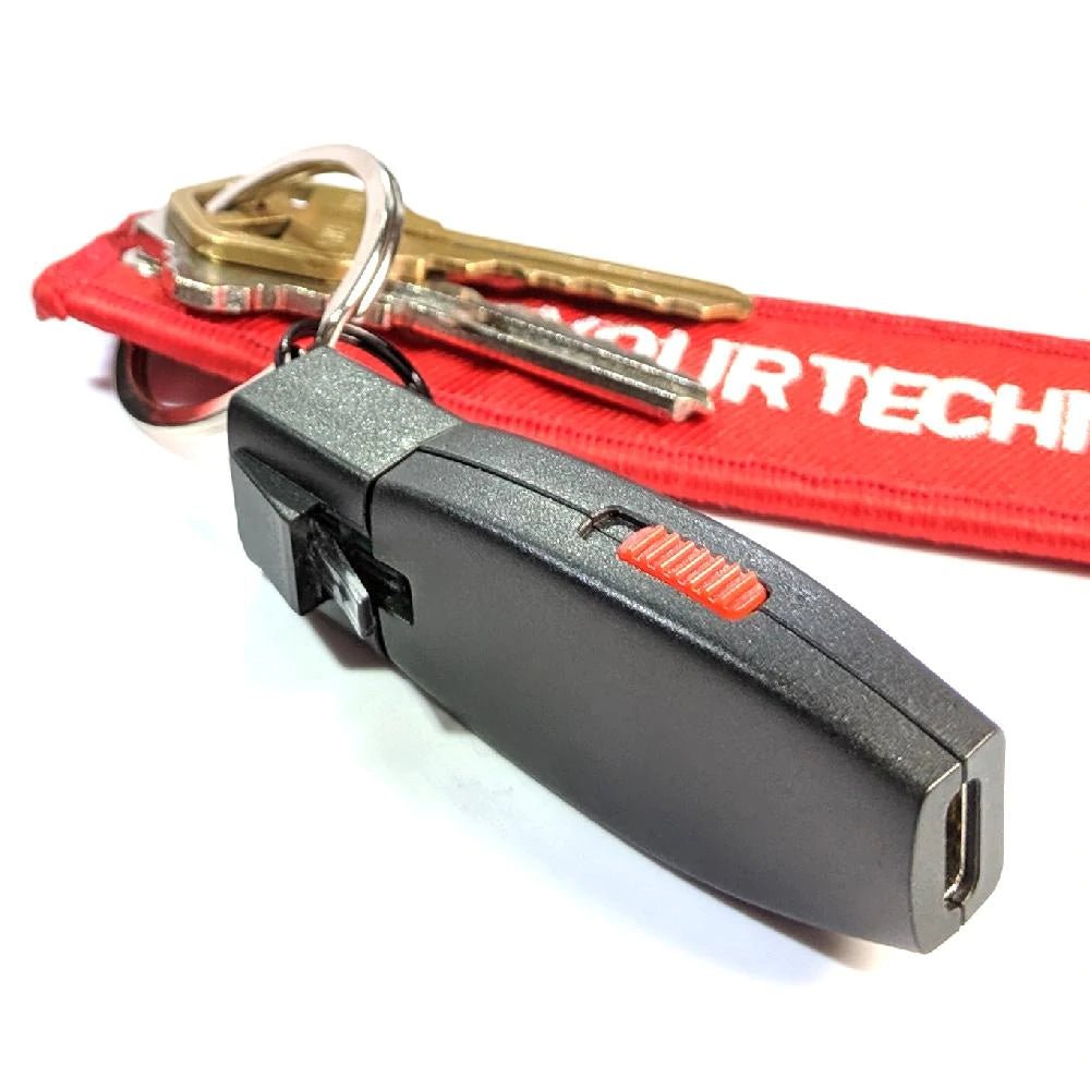 Hak5 Shark Jack przypięty do breloka z kluczami i czerwoną smyczą, widoczny czerwony przełącznik i port USB