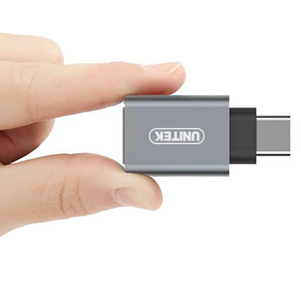 Gray Unitek Y-A025CGY OTG USB-C adapter held in fingers showing the compact size, UNITEK logo