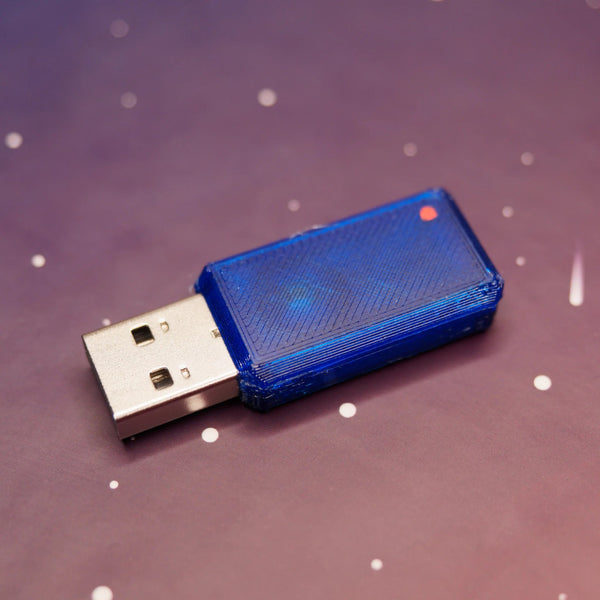 USB Nova BadUSB - urządzenie w niebieskiej półprzezroczystej obudowie z wtykiem USB-A, na fioletowym tle z gwiazdami