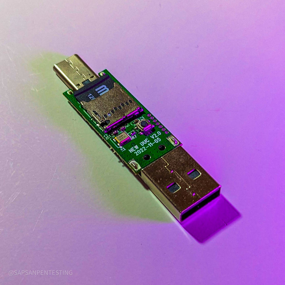 Крупный план платы USB Rubber Ducky V2 от Hak5 в фиолетовом свете - разъём USB-C, слот с картой microSD, USB-A и маркировка NEW DUC V2.0